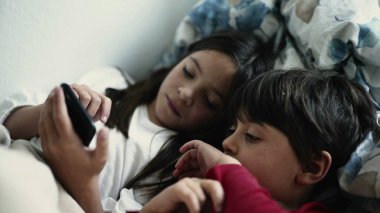 Erkek ve Kız Kardeş, Dijital Aygıt Üzerinde Kardeşler Bağlanırken Akıllı Telefon Ekranında Uzandılar