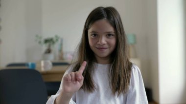 Küçük bir kız gülümseyerek seyirciye parmağını sallayarak teklifi reddediyor. Çocuk hayır diyerek el sallayarak suçlamaları savunuyor