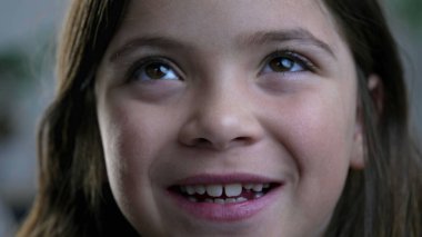 Kameraya gülümseyen neşeli küçük kızın makro yakın çekimi, 8 yaşındaki mutlu bir çocuğun sıkı yüz hatları.