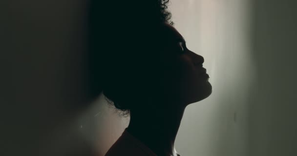 絶望している1人の若い黒人女性 孤独の壁に立ち向かうこと 苦しむ精神病 彼女の20代の孤独で苦しんでいるアフリカ系アメリカ人のシルエット — ストック動画
