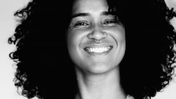 一人の幸せなブラジル人20代の若い女性は カメラで笑って カーリーヘアノッディングはい 肯定的には 黒と白です 南アメリカ人のモノクロマティックな肖像 — ストック動画
