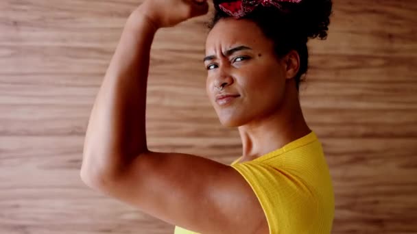 黄色いディスプレイパワーマッサージポーズとダイレクトガイズの大胆なアフリカ系アメリカ人の女性 私たちはそれを行うことができます という決定のシンボル 深刻な表現で筋肉を柔軟にする女性 — ストック動画