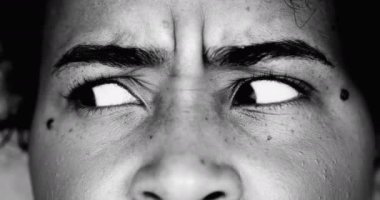 Paranoyak, genç, siyah bir kadın makro yakın çekim gözleri yoğun bir dalgınlık ve dramatik siyah-beyaz monokroma saplantısı ile yana bakıyor.