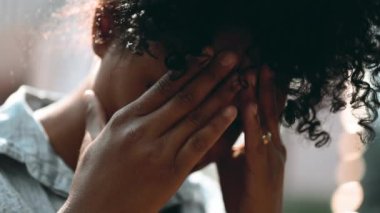 Sorunlu bir genç siyahi kadın, hayatın zorlukları sırasında baş ağrısı ve zihinsel baskıyla mücadele ediyor. Endişeli Afrikalı Amerikalı 20 'li yaşlarda yüzünü kapatan biri.