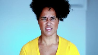 Öfkeli bir genç siyahi kadın öfkesini dile getiriyor. Kavgacı Afro-Amerikan 20 'li yaşlarda kameraya bakan kişi öfkeli hissediyor.