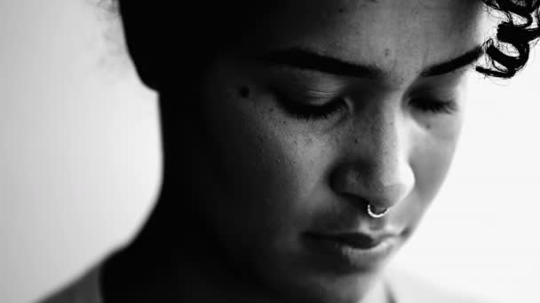 激しい黒と白で思慮深い表現で下向きを見つめているアフリカ系アメリカ人女性 — ストック動画