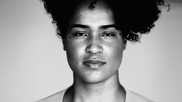若いアフリカ系アメリカ人のモノクロマティックな肖像画は 強い黒と白のカメラを見つめている 20代のブラックラティナのクローズアップフェイス — ストック動画