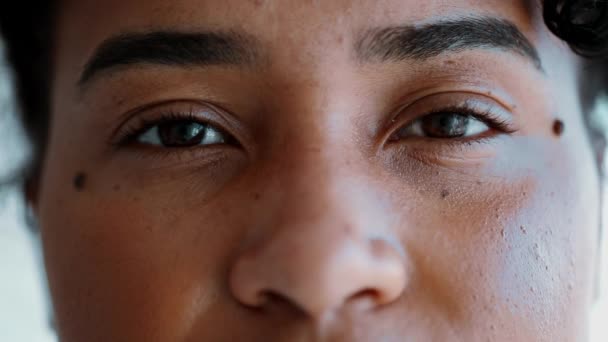 カメラを眺めているアフリカ系アメリカ人女性のマクロのクローズアップ目 中立的な表現で顔の細部の目 — ストック動画