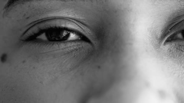 1人の若い黒人女性の目 モノクロ 白のカメラで中立的なガイズを持つ20代の人物の顔の詳細を閉じる — ストック動画
