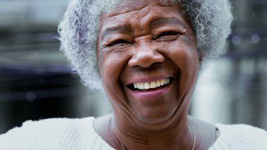 Neşeli, yaşlı, gri saçlı, kırışıklıkları olan ve mutlu, dost canlısı bir gülümsemesi olan yaşlı kadın. Afrika kökenli portrelerin karizmatik Güney Amerika kıdemli şahsiyeti