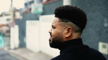 Düşünceli, genç, siyah Brezilyalı bir adamın düşünceli bir ifadeyle şehir ortamında yürümesi. Düşünceli Güney Amerikalı.