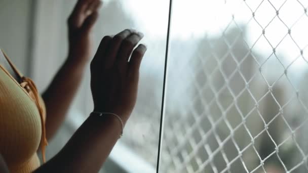 アパートのバルコニーのガラス窓のクローズアップ手は穏やかに傾いています 孤立と孤独を象徴する屋内から外を眺める人 — ストック動画