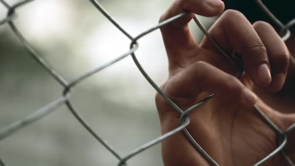 Close Hand Holding Metal Fence Barrier Symbolizing Entrapment Cage Person — Stock Video