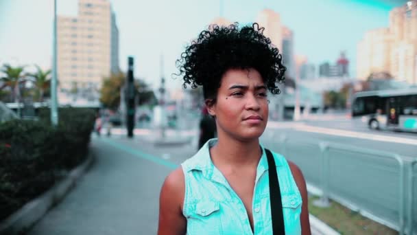 年轻的非洲裔美国妇女走在城市背景的前面 一个沉思的20多岁的黑人姑娘走在人行道上 — 图库视频影像