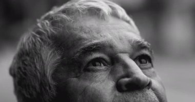Ruhani kıdemli adam, umut dolu bakışlarla gökyüzüne bakıyor. Yoğun dramatik, siyah-beyaz, 70 'li yaşlarda ilahi yardım ve destek arayan beyaz saçlı, yakın plan gözleri.