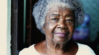 Kameraya bakan kıdemli Afrikalı Amerikalı kadın portresi. 80 'li yaşlarda, kırışıklıkları ve ciddi ifadesi olan gri saçlı yaşlı bir kadın. Yüzü kapat