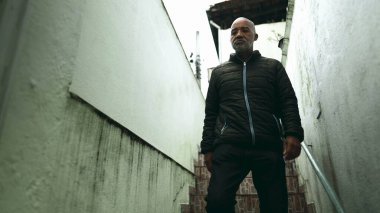 Son sınıf siyahi bir adam merdivenlerden inip Güney Amerika 'da konutun ön kapısını açıyor. Yağmur yağarken şehir kaldırımına çıkıyor. 50 'li yaşlarda Afrika kökenli biri evi terk ediyor.