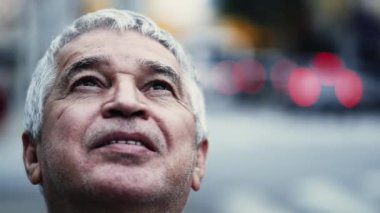 Umut dolu yaşlı adam İlahi Huşu içinde gülümsüyor, Şehir Caddesinde Yukarı Bakışlar Yakından İzleme, 70 'li yaşlarda UMUT ve FAITH sahibi erkek.