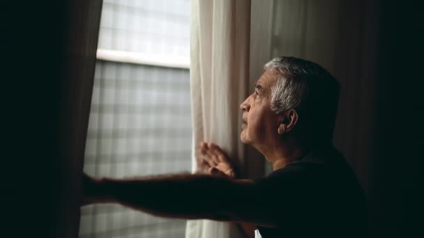 Thoughtful Senior Man Peering Window Curtains Elderly Observing Neighborhood Home — Stock Video