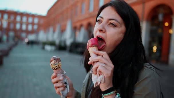 Женщина Наслаждается Двумя Морожеными Стоящими Европейском Городе Поедая Мороженое Конусом — стоковое видео