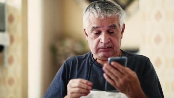 Ældre Mand Sætte Læsebriller Holder Mobiltelefon Enhed Erne Kaukasiske Grå – Stock-video