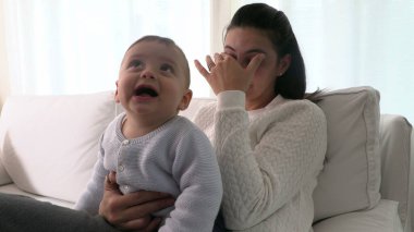 Yorgun bir anne gözlerini ovuşturuyor. Bitkin hissediyorum.