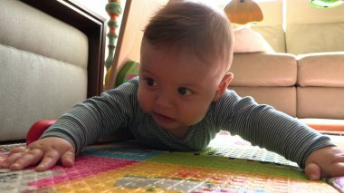 Tatlı erkek bebek emeklemeyi öğreniyor.