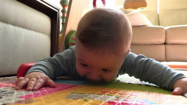 Tatlı erkek bebek emeklemeyi öğreniyor.