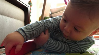 Bebek çocuk kendi kendine ve kendi evinde oynuyor.