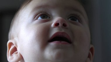 Bebek yüzlü, gülümseyerek dünyayı öğreniyor.