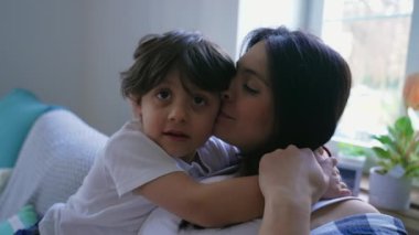 Anne ve çocuğun şefkatle kucaklandığı bir ev sahnesi. Gerçek hayatta anne ve oğul birbirlerine sevgi ve sevgiyle sarılırlar.