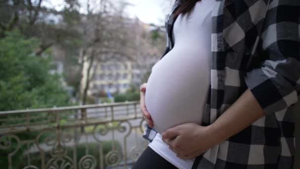 孕妇在公寓阳台上爱抚8个月的腹部 表现出对新生儿的爱和感情 — 图库视频影像