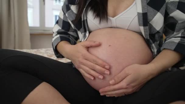 妊娠中の腹は生まれていない赤ん坊を愛し クローズアップ手優しく3番目のトリメスターベリーに触れる — ストック動画