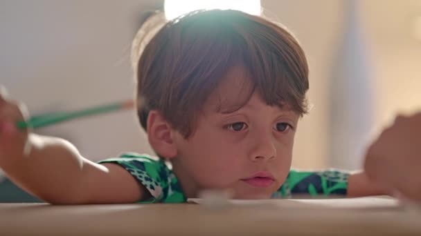 Μικρό Αγόρι Πηγούνι Στο Τραπέζι Και Ταλάντευση Μολύβι Στο Χέρι — Αρχείο Βίντεο