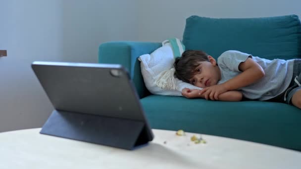 Маленький Хлопчик Лежить Дивані Відволікає Себе Дивитися Мультфільм Планшеті Дитина — стокове відео