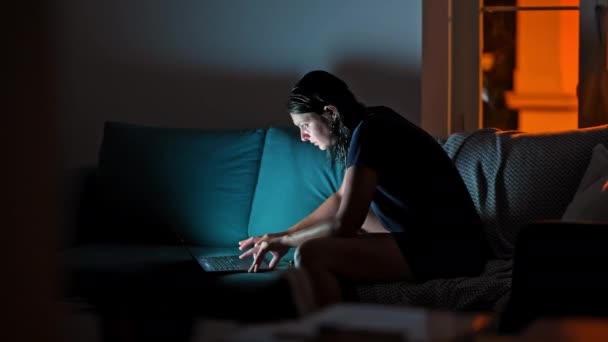 Nighttime Computing Kvinna Soffa Med Laptop Och Hörlurar Dimly Lit — Stockvideo