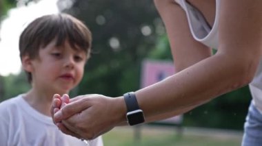 Anne, sıcak yaz gününde çocuğa musluktan su içmesi için yardım ediyor - Oğlu su içebilsin diye elleriyle bir kase oluşturuyor