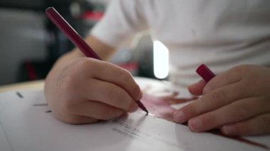 Kağıt üzerine renkli kalemle çizim yapan çocuk elleri