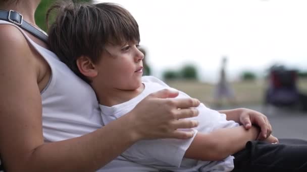 Kleiner Junge Verlässt Den Schoß Der Mutter Auf Parkbank Sitzend — Stockvideo
