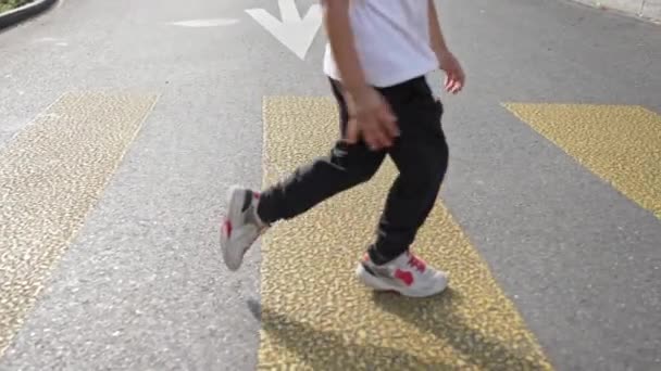 Glückliches Kind Überspringt Den Bürgersteig Und Den Fußgängerüberweg Beim Überqueren — Stockvideo