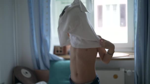 小孩穿上T恤 小男孩穿上自己的衣服 站在卧室里穿上白衬衫 5岁的高加索男孩 — 图库视频影像