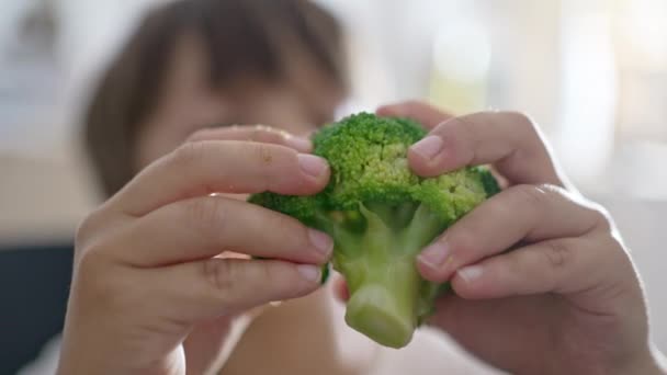 选择性的孩子用他的手从花椰菜中分离出他要吃的东西 — 图库视频影像