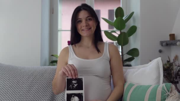 어머니는 초음파 이미지를 엄마는 애무하고 태어나지 아기를보고 임신에서 집에서 소파에 — 비디오