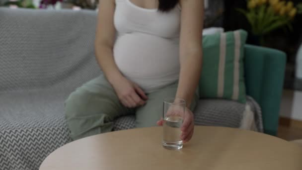 Zwangere Vrouw Pakt Een Glas Water Zittend Thuisbank Derde Trimester — Stockvideo