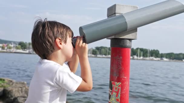Маленький Мальчик Наблюдает Ландшафтом Краю Озер Через Стационарный Общественный Телескоп — стоковое видео