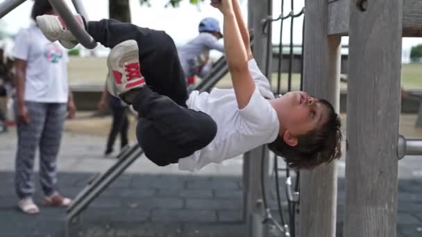 在游乐场金属平台上测试身体极限 小男孩尝试杂技 — 图库视频影像