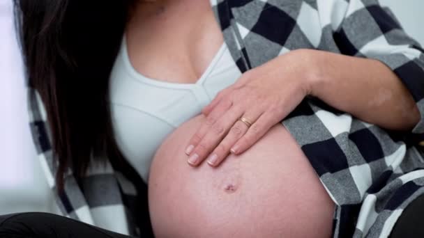 30代の女性は 妊娠した腹部を後期段階 妊娠の第三期 優しく腹に触れるクローズアップ手を世話します — ストック動画
