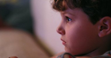Child watching TV screen,young boy staring to screen