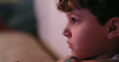 Child watching TV screen,young boy staring to screen