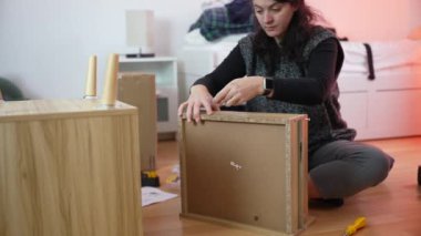 Mobilya montajı yapan kadın, yeni ev toplantısına taşınan kişi. DIY geliştirme